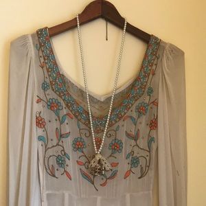 Long pearl necklace with bird in cage charm